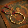 Pulsera Tibetana de la Fortuna sobre un thangka tibetano